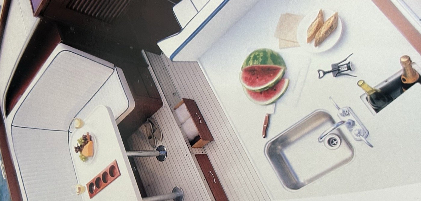 Skiff Craft galley with mahogany cabinetry and stainless sink.